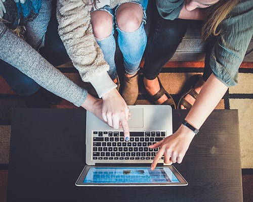 People pointing at computer