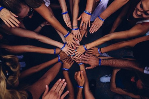 Group of people putting their hands together