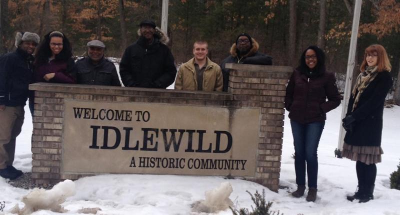 Photo of Idlewild team behind a 'Welcome to Idlewild' sign in the snow