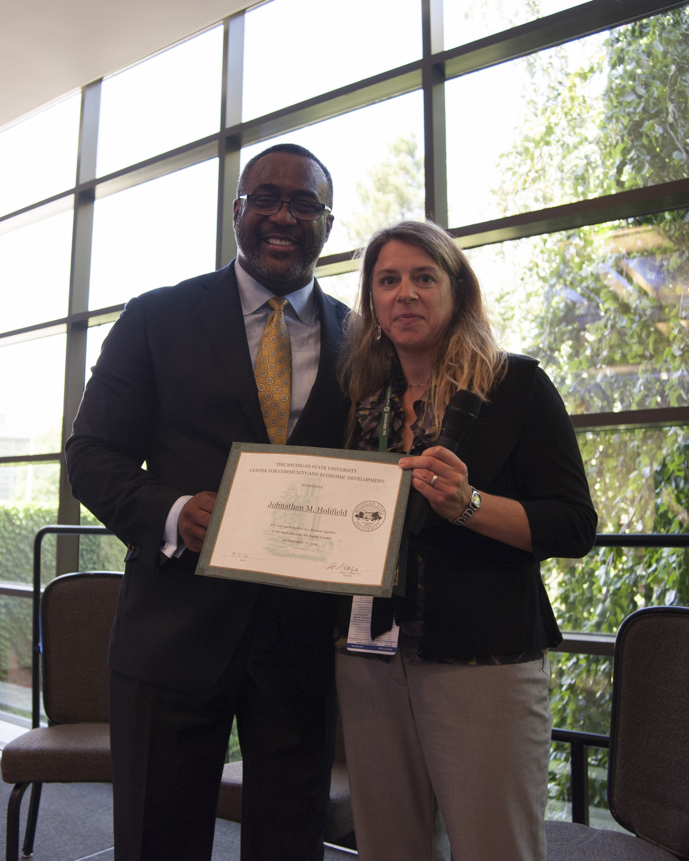 Jennifer Bruen presents Johnathan Holifield with a certificate for attending the Summit